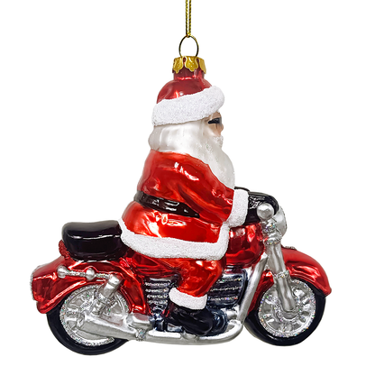 Glass ornament of Santa Claus riding a motorcycle on a white background