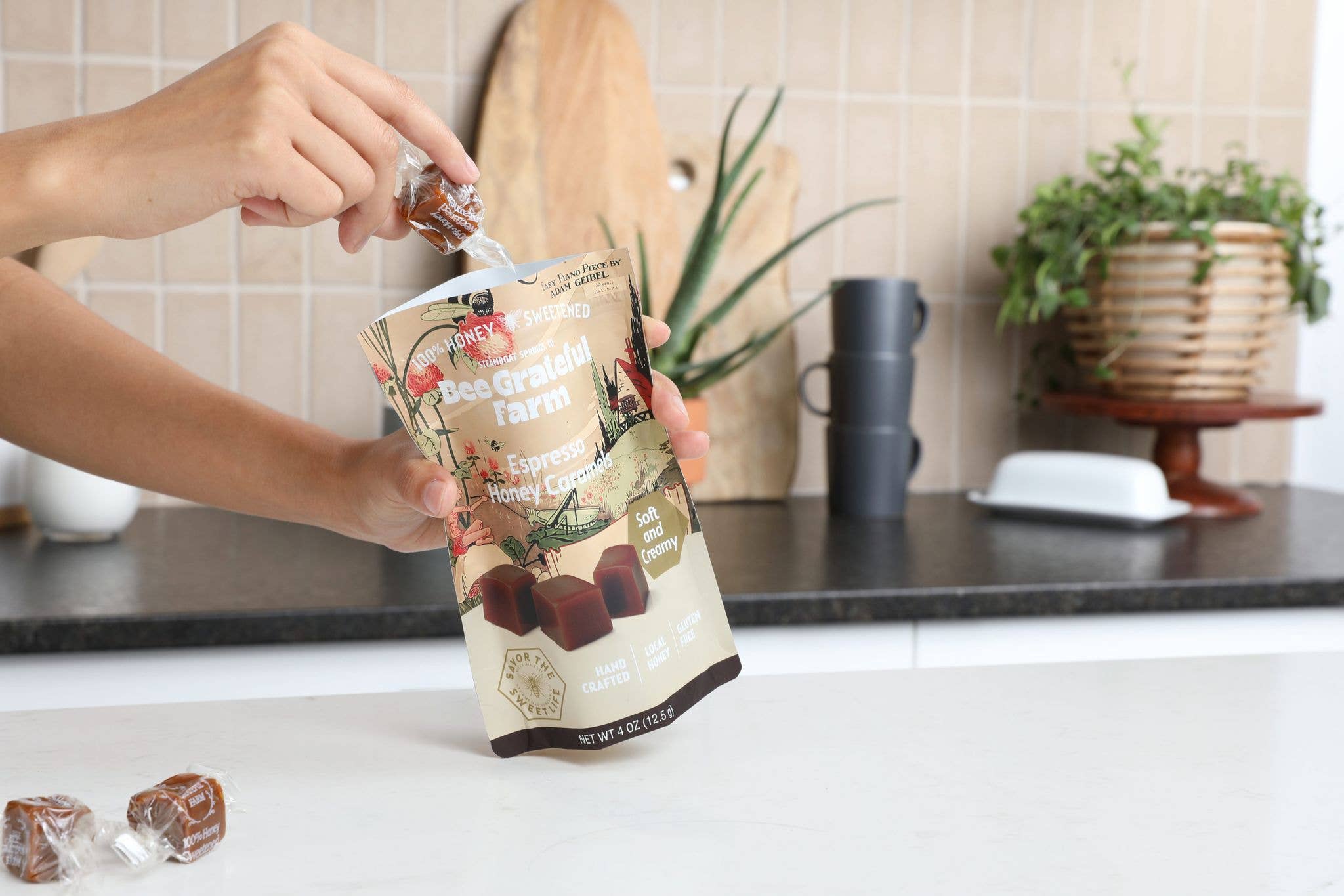 Person getting a caramel from an open bag of espresso honey caramels