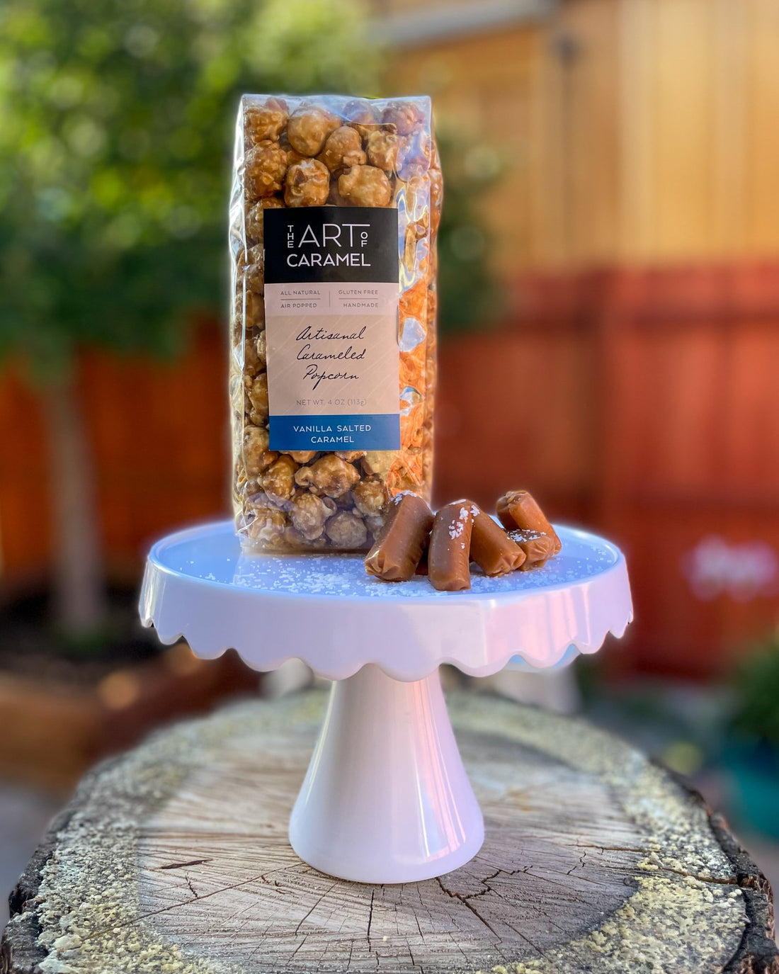 Vanilla Salted Caramel Popcorn on Stand with Caramels and Sea Salt
