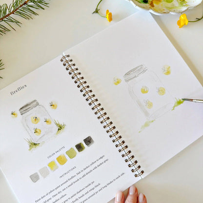 Open book with illustrations of jars and color palettes on a light surface.