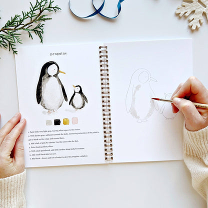 Person drawing penguins in a sketchbook with a coloring guide