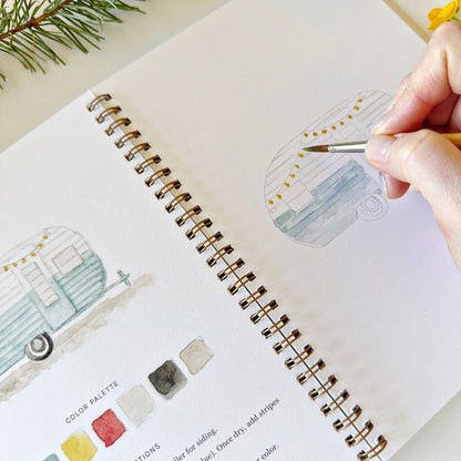 Person painting a small vehicle illustration in a notebook with a pen.