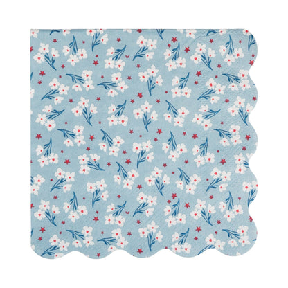 Floral patterned paper napkin with white flowers and blue leaves on a light blue background