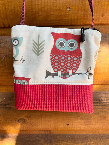 Small purse with owl design on a wooden surface