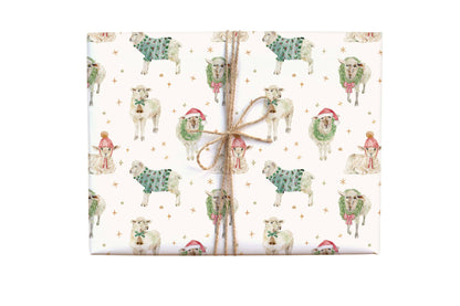 Gift wrap with Christmas-themed design of sheep and children in Santa hats on a white background