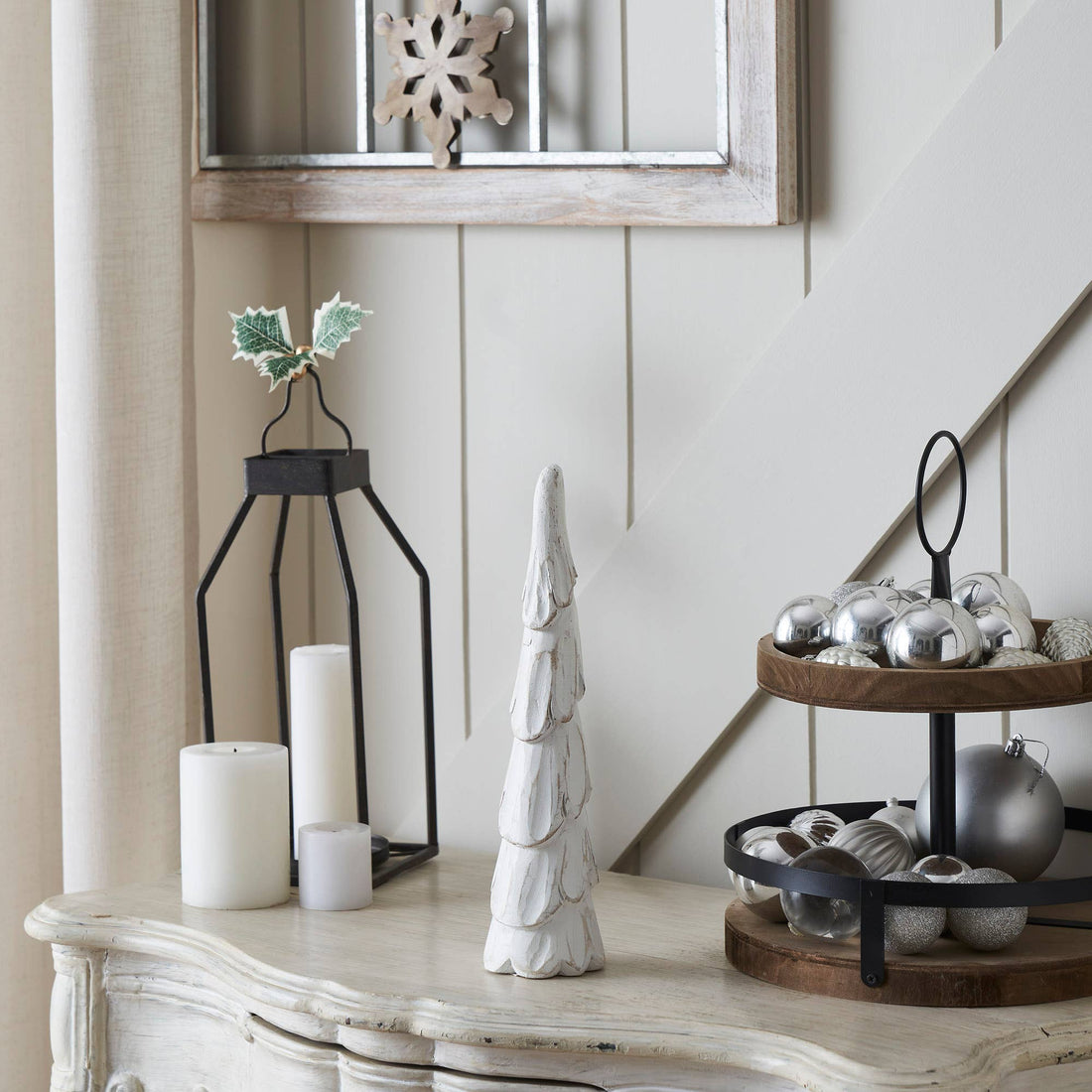 Decorative items on a table including candles, a tree, and ornaments.