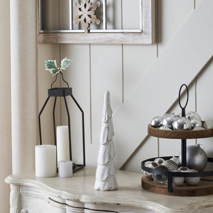 Decorative items on a table including candles, a tree, and ornaments.