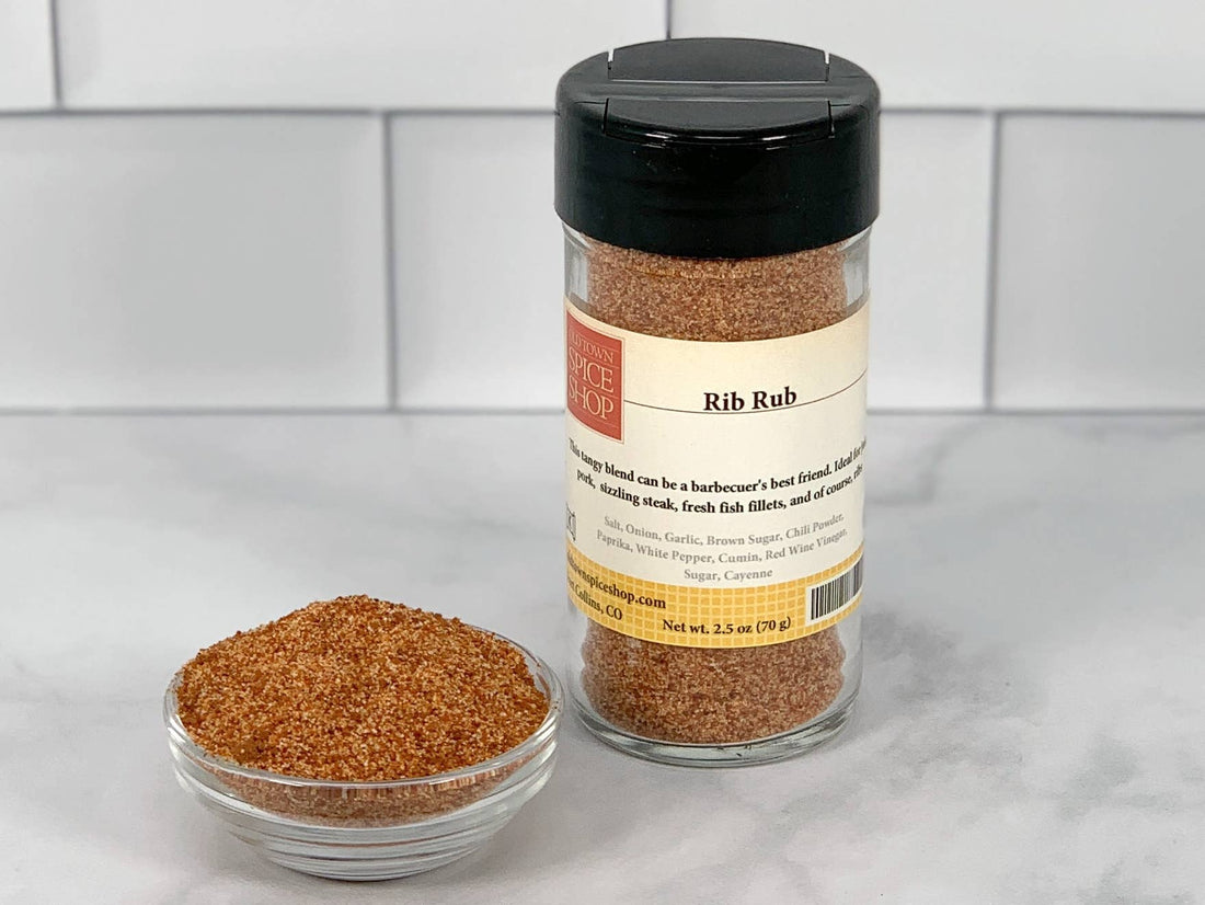 A clear glass container with a black lid, labeled &