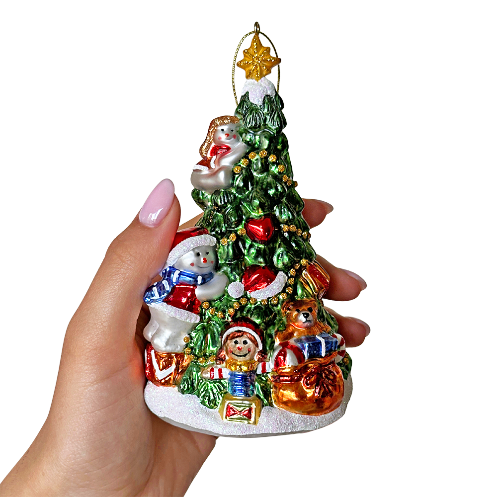 Hand holding a small Christmas tree ornament with Santa Claus, snowman, and presents on a white background