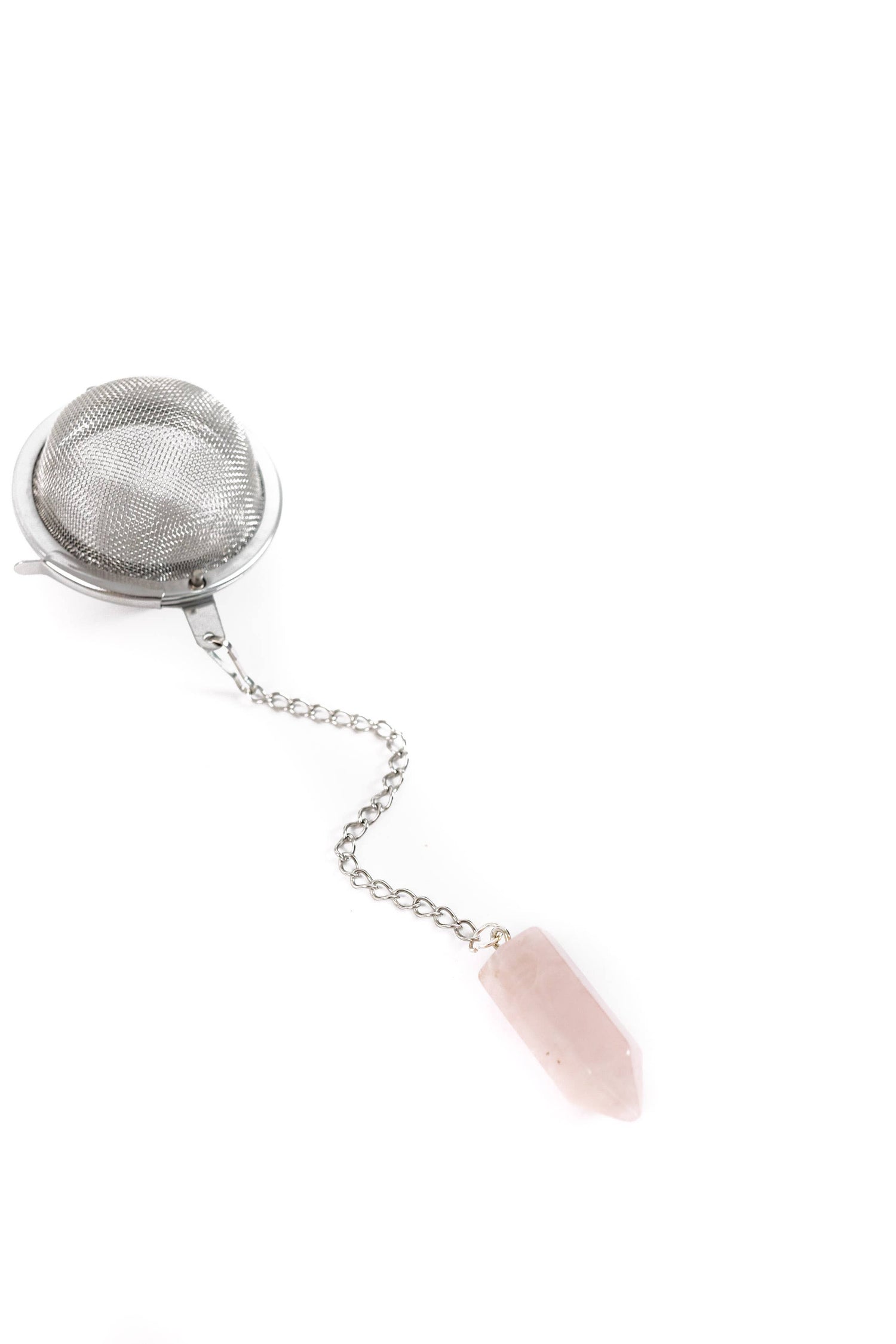 Metallic tea infuser with a pink stone on a white background