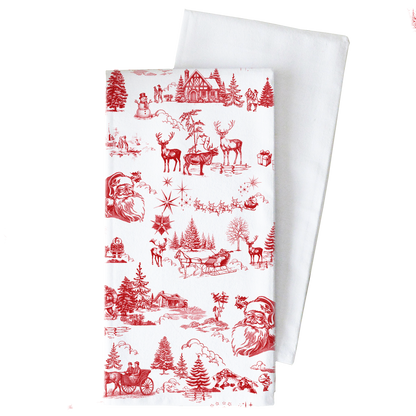 A white fabric tea towel with a red Christmas toile pattern, shown folded with a second plain white towel behind it on a white background.