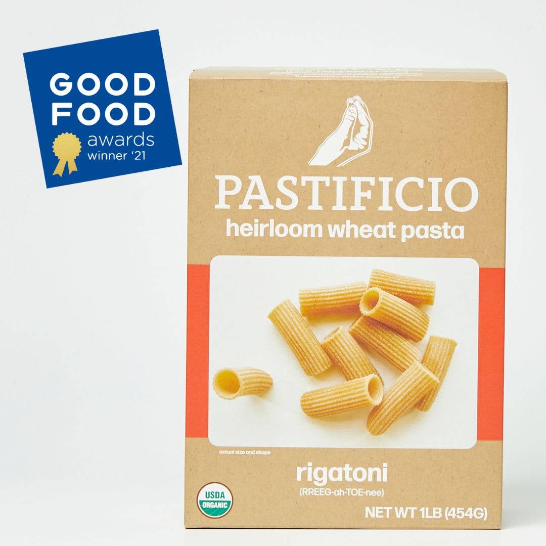 A 1 lb box of Pastificio Heirloom Wheat Pasta Rigatoni on a white background, featuring a blue Good Food Awards 2021 badge in the top left corner.