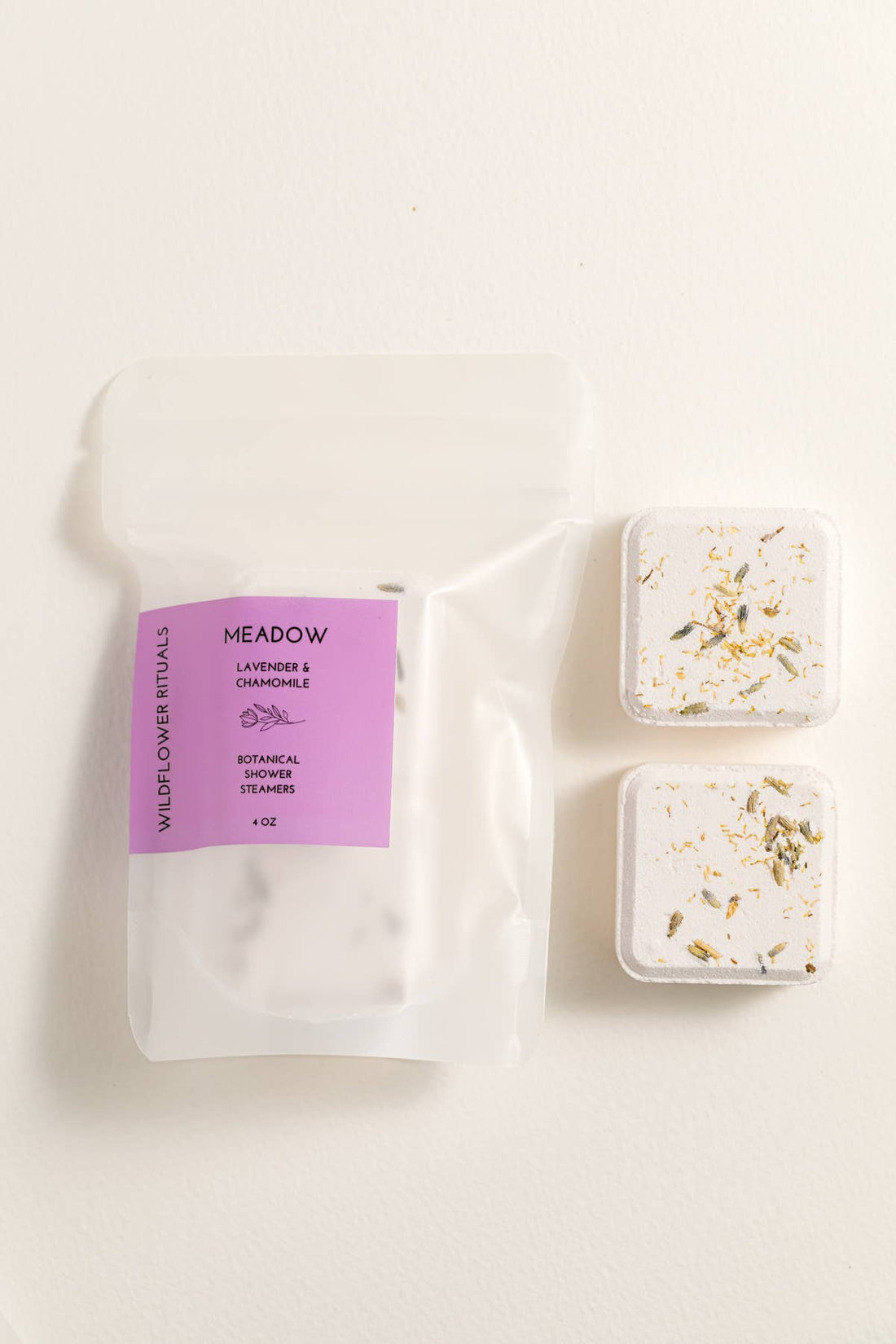 Two shower steamers with a packaging bag labeled &