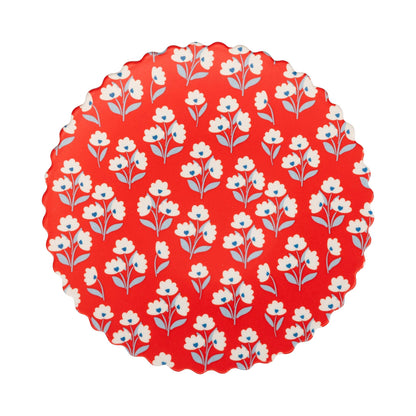 Round red bamboo plate with white and blue floral pattern on a white background