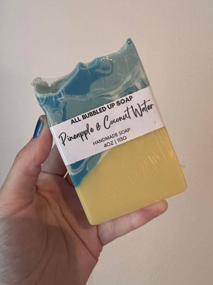 Hand holding a bar of soap with a label reading &