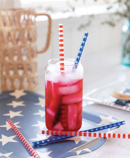 Glass of red iced drink with straws on a tablecloth with star pattern
