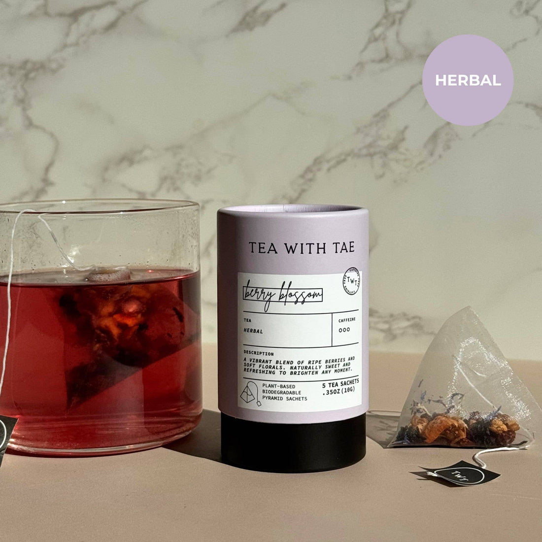 Tea with Tae herbal tea canister next to a glass of iced tea with a tea bag.