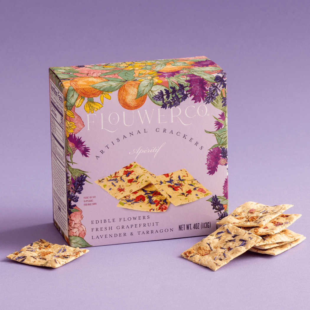Flourish Co. crackers with a colorful box on a purple background