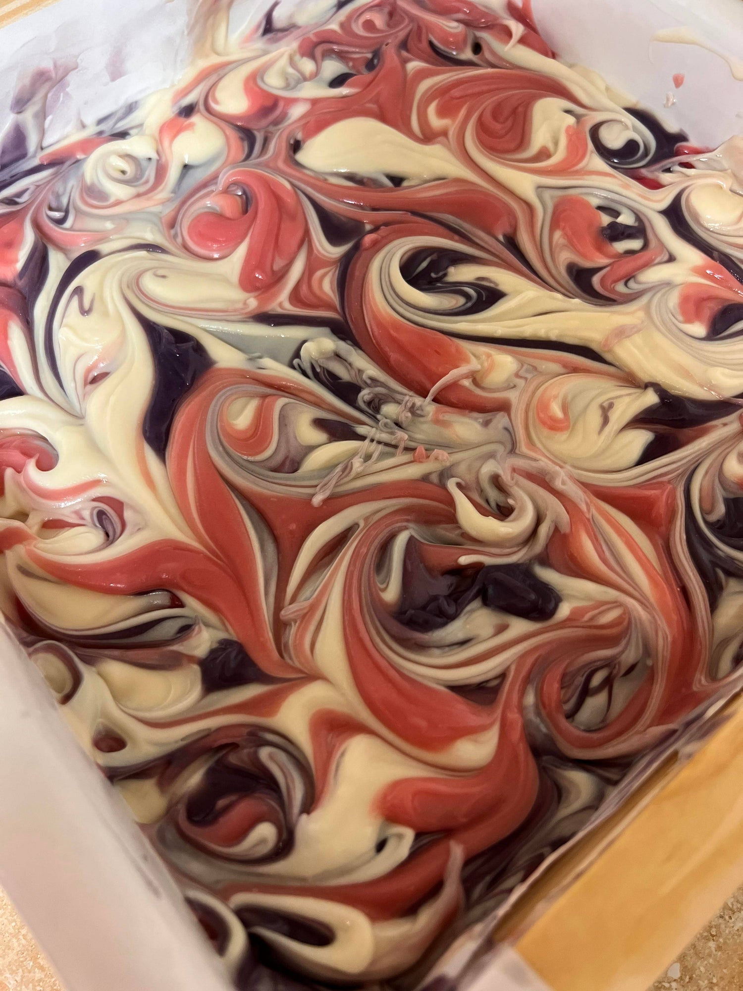 Swirl pattern of red, white, and black colors on a surface.