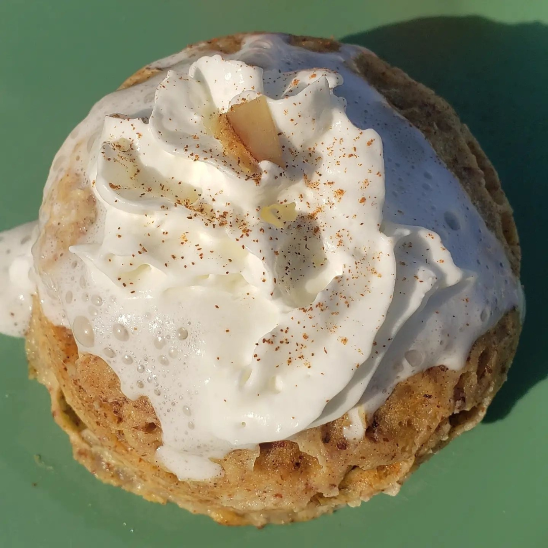 Pastry with white cream and cinnamon on a green background