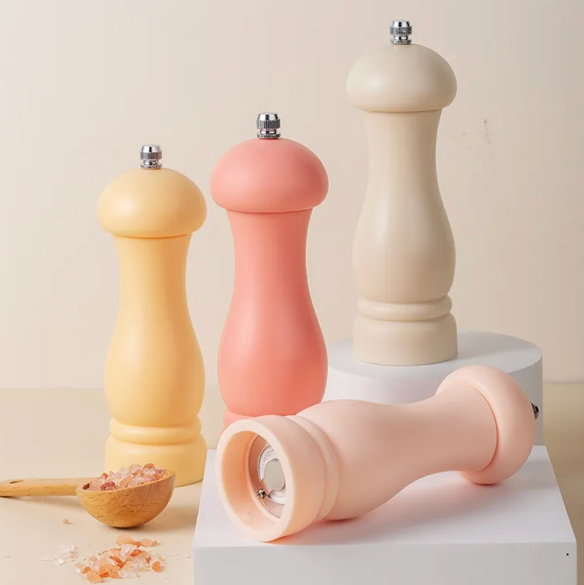 Set of colorful pepper mills on a neutral background