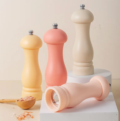 Set of colorful pepper mills on a neutral background