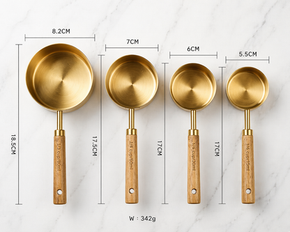 Set of four brass measuring spoons with wooden handles, shown with measurements on a white background.