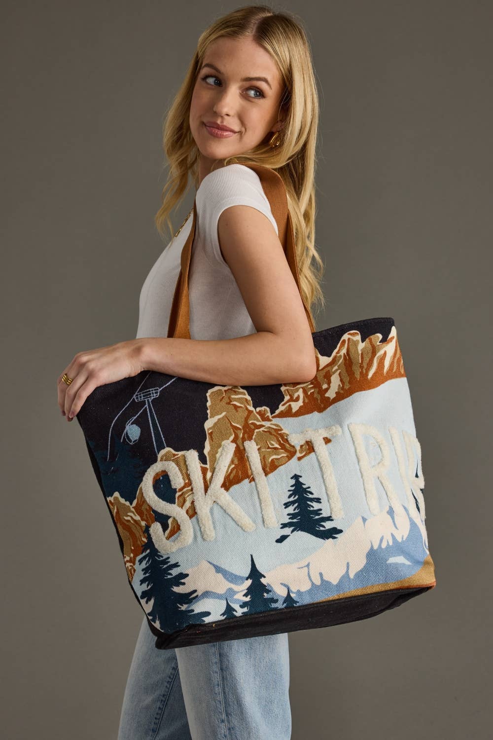 Woman holding a tote bag with mountain and skiing design