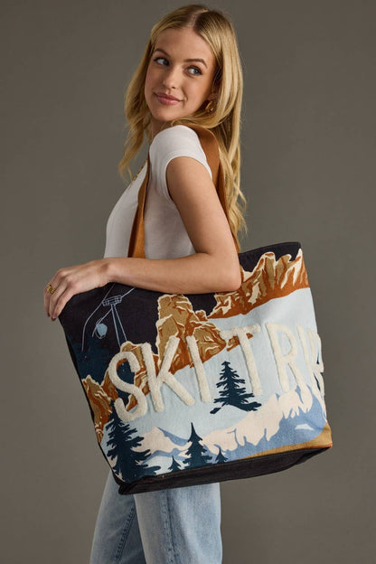 Woman holding a tote bag with mountain and skiing design