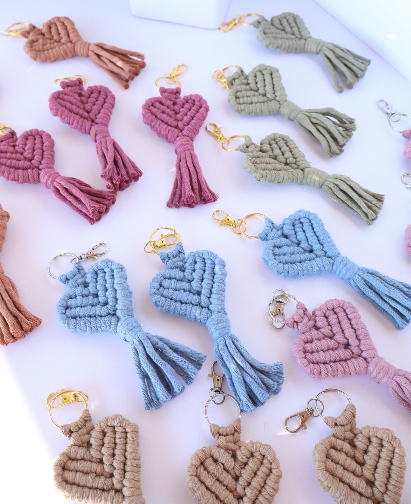 Set of colorful macrame keychains on a white surface with a blurred background